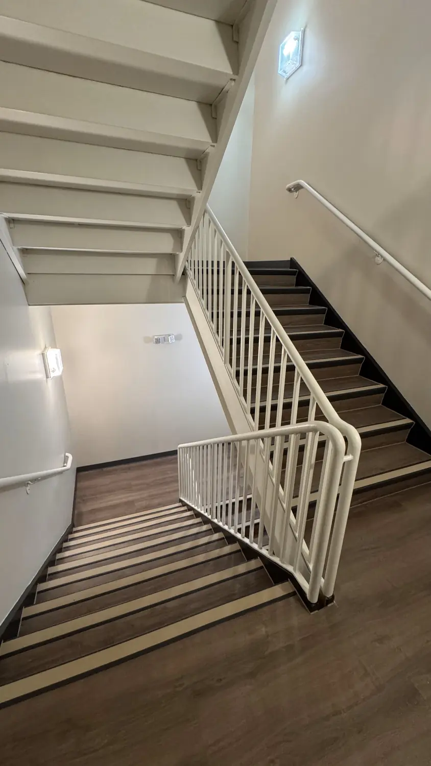 Renovated stairwell with new flooring and railing